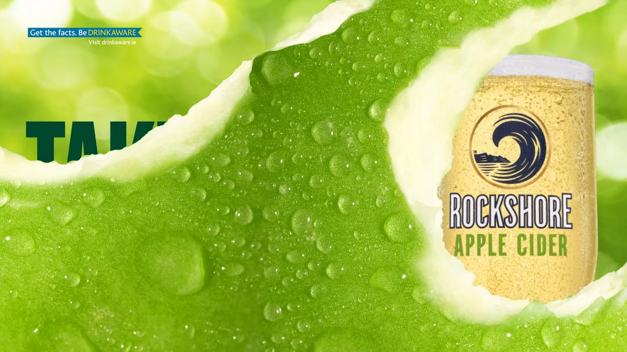 An ice-cold pint of cider with a green bokeh background